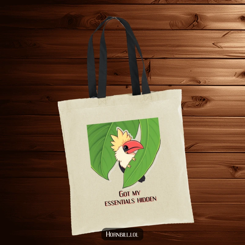 Funny chubby hornbill peeking from behind a large leaf, a delightful and humorous surprise on this tote bag.